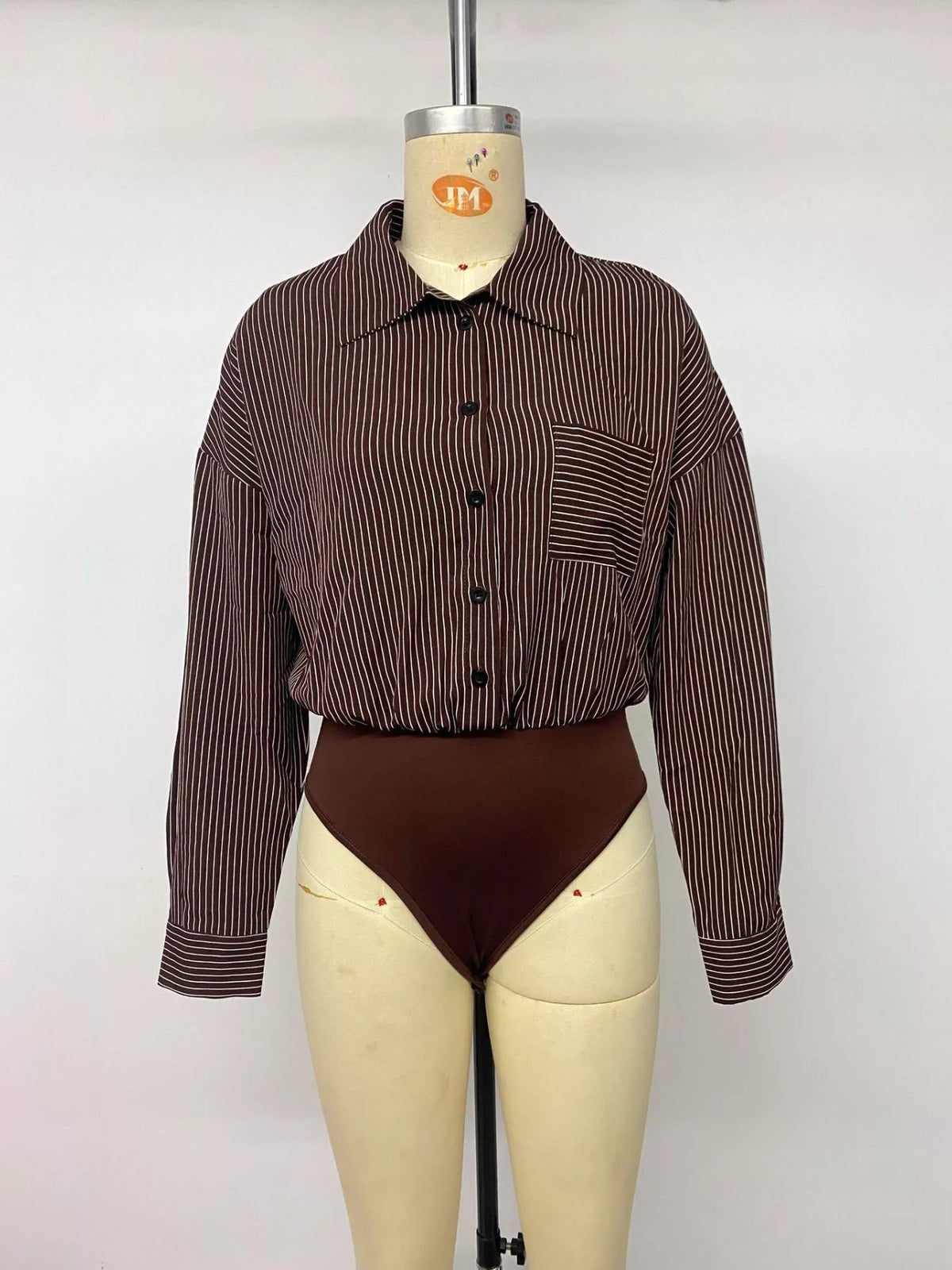 Mannequin front view of brown pinstripe button-up bodysuit showing full button front and brief bottom