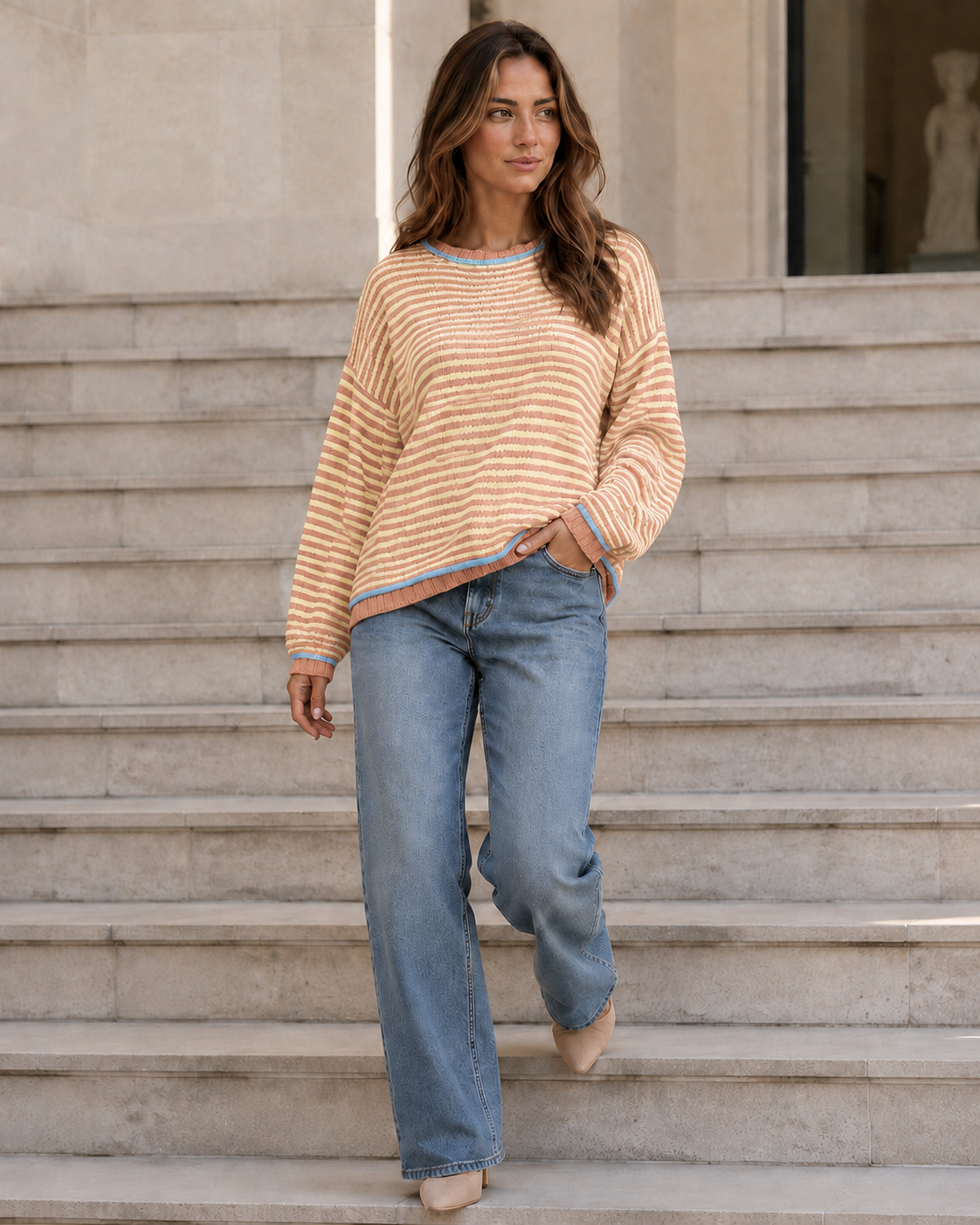 Kira Striped Dropped-Shoulder Sweater in Orange-Red, walking on steps